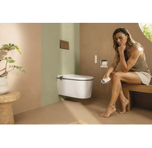 Salle de bains moderne avec toilette douche suspendue, télécommande et décoration minimaliste dans des tons terreux.