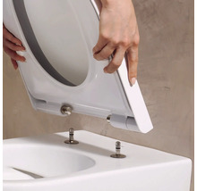 Abattant de WC avec fonction Take-Off posé sur les boulons de fixation d'un WC.