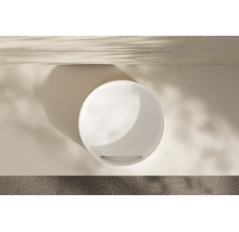 Draufsicht auf ein rundes weißes Waschbecken in einem modernen hellen Badezimmer mit weichem Lichteinfall und Schatten.