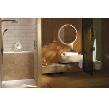 Salle de bains moderne aux tons terre avec douche à l'italienne, meuble sous-vasque suspendu, miroir rond rétroéclairé et WC suspendu.