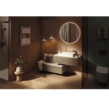 Salle de bains moderne avec miroir rond rétroéclairé, vasque à poser blanche sur meuble suspendu, espace douche et WC suspendu.