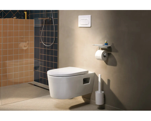 Salle de bains moderne avec WC suspendu, plaque de déclenchement, porte-rouleau avec tablette et brosse de toilette en blanc sur un mur beige.