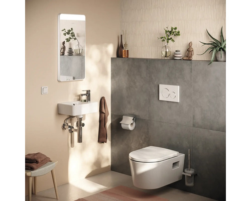 Toilettes d'invités modernes avec toilette suspendue, petit lavabo, miroir éclairé et carrelage mural gris foncé.