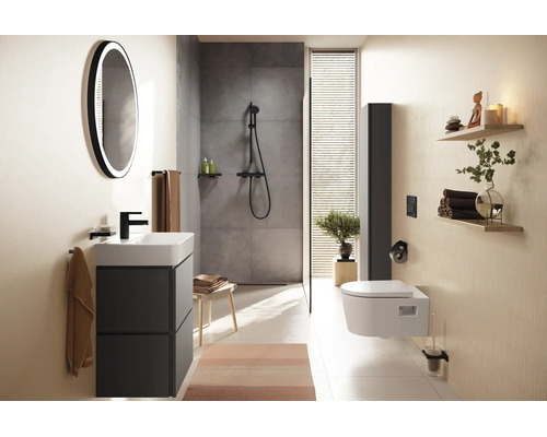 Salle de bain moderne avec meuble sous-lavabo anthracite, miroir LED rond, douche à l'italienne et WC suspendu blanc.