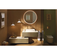 Salle de bains moderne et organisée avec miroir LED rond, vasque à poser blanche sur meuble suspendu et WC suspendu.