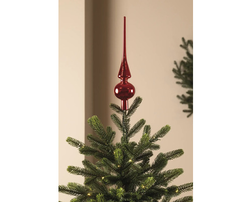 Cimier de sapin de Noël rouge brillant sur un sapin de Noël vert avec de petites lumières.
