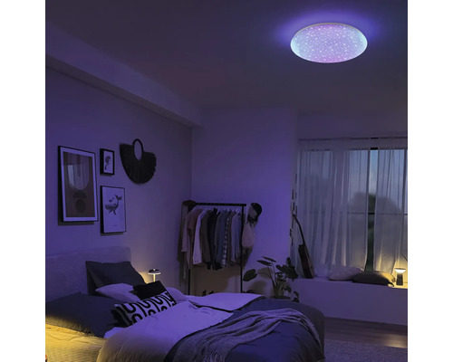 Modernes Schlafzimmer mit runder LED-Deckenleuchte mit Sternenhimmel-Effekt und lila stimmungsvoller Beleuchtung.