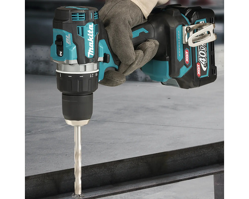 Perceuse-visseuse à percussion sans fil Makita de la série 40 Volt XGT perçant une poutre métallique avec un foret à métaux.
