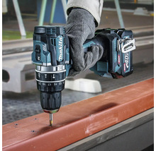 Perceuse-visseuse sans fil Makita 40 Volt XGT perçant un profilé métallique, tenue par une main avec gant de travail.
