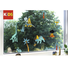 Logo Marabu Kids, décorations de fenêtre avec motifs de dinosaures, palmiers et volcan sur une vitre.