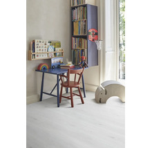 Chambre d'enfant lumineuse et organisée avec bureau en bois bleu, chaise rouge et étagères sur un sol stratifié clair aspect bois.