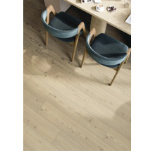 Sol stratifié à l'aspect bois clair avec veinage dans une salle à manger sous deux chaises et une table.