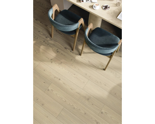 Sol stratifié à l'aspect bois clair avec veinage dans une salle à manger sous deux chaises et une table.