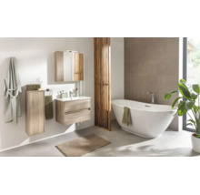 Salle de bains moderne avec baignoire en îlot, meuble sous-vasque aspect bois, lavabo, armoire de toilette et armoire haute.