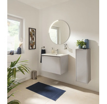 Salle de bains moderne avec meuble sous-vasque suspendu, miroir LED rond, armoire latérale et accessoires assortis dans un design clair.