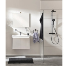 Salle de bain moderne et lumineuse avec meuble sous lavabo, armoire de toilette, robinetterie noire et douche italienne avec système de douche noir.