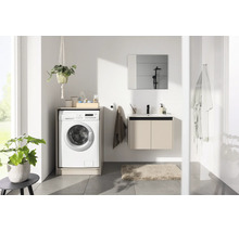 Salle de bains lumineuse avec lave-linge intégré dans un meuble, meuble sous-vasque suspendu avec lavabo et miroir.