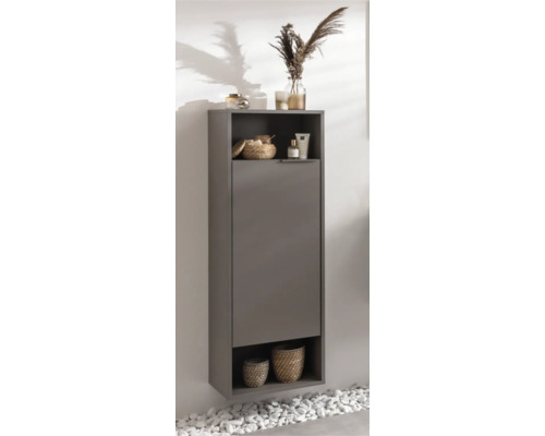 Armoire haute de salle de bain grise avec une porte et deux compartiments ouverts, décorée de paniers et d'accessoires de salle de bain.