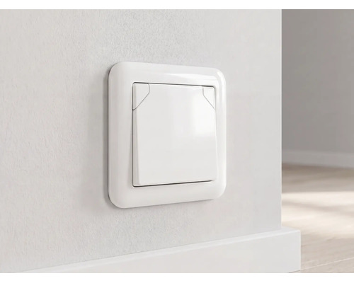 Weiße Unterputz-Steckdose mit Klappdeckel, an einer hellen Wand über einer Fußleiste montiert.
