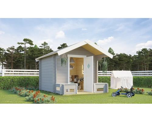 Maisonnette pour enfants en bois avec toit à deux pans dans un jardin lumineux avec pelouse, clôture blanche et kart à pédales.