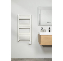 Radiateur sèche-serviettes électrique en forme d'échelle dans la salle de bain à côté d'un meuble sous-vasque en bois et d'un miroir.