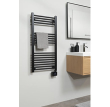 Sèche-serviette noir avec thermostat numérique dans la salle de bains à côté d'un meuble sous-vasque en bois avec lavabo et miroir.