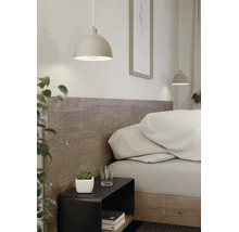 Suspension moderne en forme de demi-sphère au-dessus d'une table de chevet noire dans une chambre lumineuse avec tête de lit en bois.