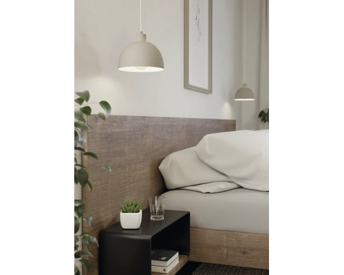Suspension moderne en forme de demi-sphère au-dessus d'une table de chevet noire dans une chambre lumineuse avec tête de lit en bois.