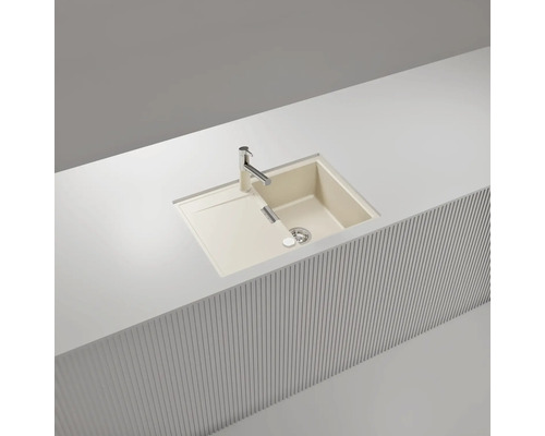 Évier à encastrer beige en composite de quartz avec un bac, un égouttoir et un robinet, encastré dans un plan de travail blanc.