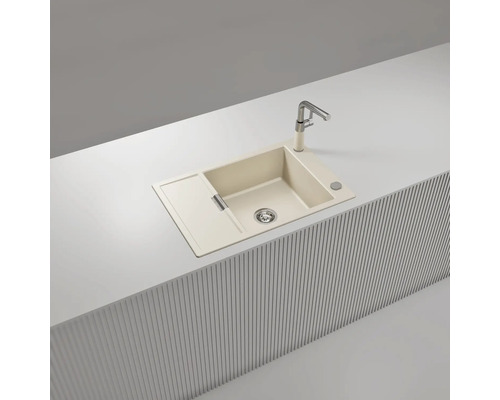 Évier de cuisine encastrable beige en matériau composite avec un bac, un égouttoir et un robinet, installé sur un plan de travail moderne.