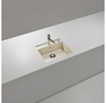 Évier de cuisine moderne à un bac en matériau composite beige, encastré à fleur dans un plan de travail blanc avec robinet chromé.