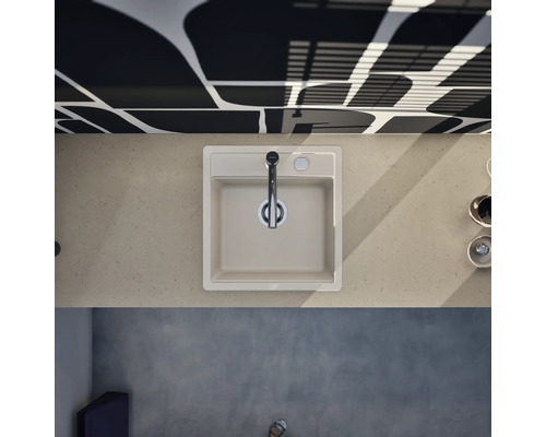 Évier de cuisine carré dans un plan de travail avec robinet moderne, vue de dessus dans une cuisine lumineuse et organisée.