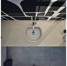 Vue de dessus d'un évier de cuisine en composite beige dans un plan de travail assorti avec un robinet chromé.