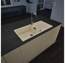 Îlot de cuisine moderne avec évier encastré beige, égouttoir et robinet haut sur un plan de travail sombre.