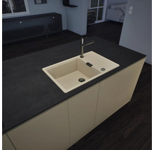 Évier encastrable en composite de quartz dans un îlot de cuisine sombre avec robinetterie moderne dans une cuisine lumineuse.