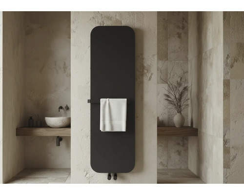 Radiateur vertical plat moderne dans une salle de bains avec murs en pierre, vasque et porte-serviette avec serviette blanche.