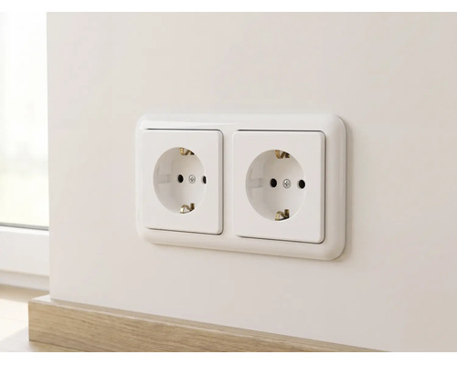 Double prise de courant avec terre montée horizontalement sur un mur au-dessus d'une plinthe.
