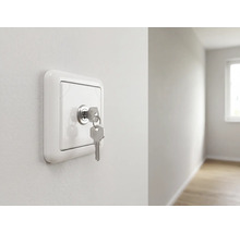Schlüsselschalter an einer Wand montiert mit eingestecktem Schlüssel in einem hellen, modernen Raum.