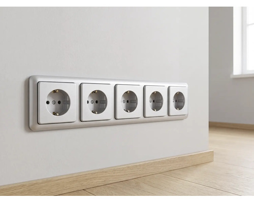 Fünf horizontal angeordnete Schutzkontakt-Steckdosen in einem Rahmen an einer Wand über einem Holzfußboden in einem hellen, organisierten Raum.
