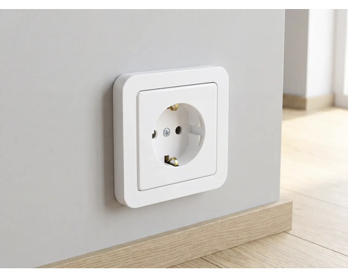 Weiße Schutzkontakt-Steckdose mit abgerundetem Rahmen an einer Wand über einer Fußleiste aus Holz.