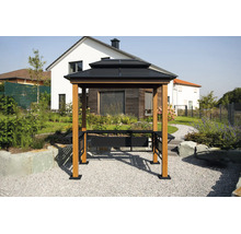 Pavillon de barbecue avec un double toit sombre, des poteaux en bois clair et des étagères latérales dans un jardin devant une maison.