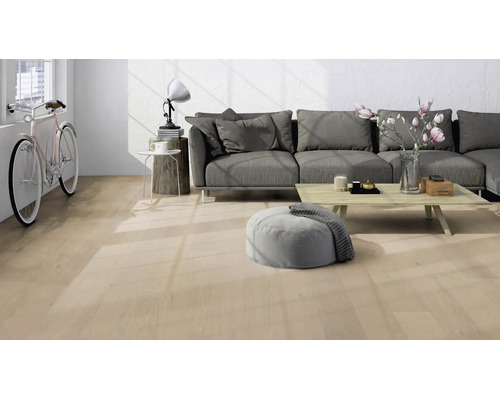 Sol clair aspect bois dans un salon moderne et lumineux avec canapé gris, table basse et un vélo contre le mur.