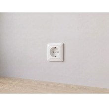Prise de courant avec mise à la terre blanche installée sur un mur.