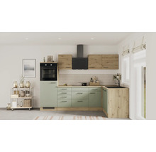 Moderne Einbauküche in L-Form mit salbeigrünen Fronten, Holzelementen, schwarzem Backofen und Dunstabzugshaube in einem hellen Raum.