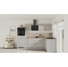 Cuisine moderne en L avec façades gris clair brillantes, plan de travail en bois, four noir et hotte aspirante dans une pièce lumineuse.