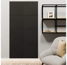 Panneau mural anthracite avec motif à chevrons sur un mur clair à côté d'une étagère en métal noire et d'un fauteuil dans un salon moderne.