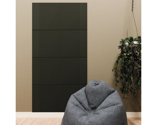 Panneaux acoustiques muraux sombres à lamelles verticales, installés sur un mur derrière un pouf gris et une plante suspendue.