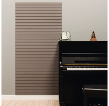 Panneau acoustique avec lattes horizontales sur un mur à côté d'un piano noir dans une pièce lumineuse.
