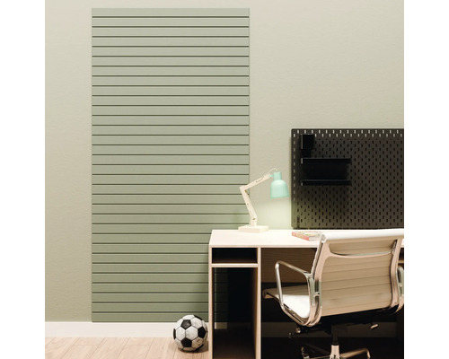 Un panneau mural vert à lattes horizontales à côté d'un bureau avec chaise de bureau et un panneau perforé noir.