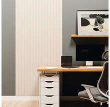 Espace de travail moderne avec panneaux muraux clairs, bureau en bois, écran, ordinateur portable et caisson à tiroirs blanc devant un mur gris.